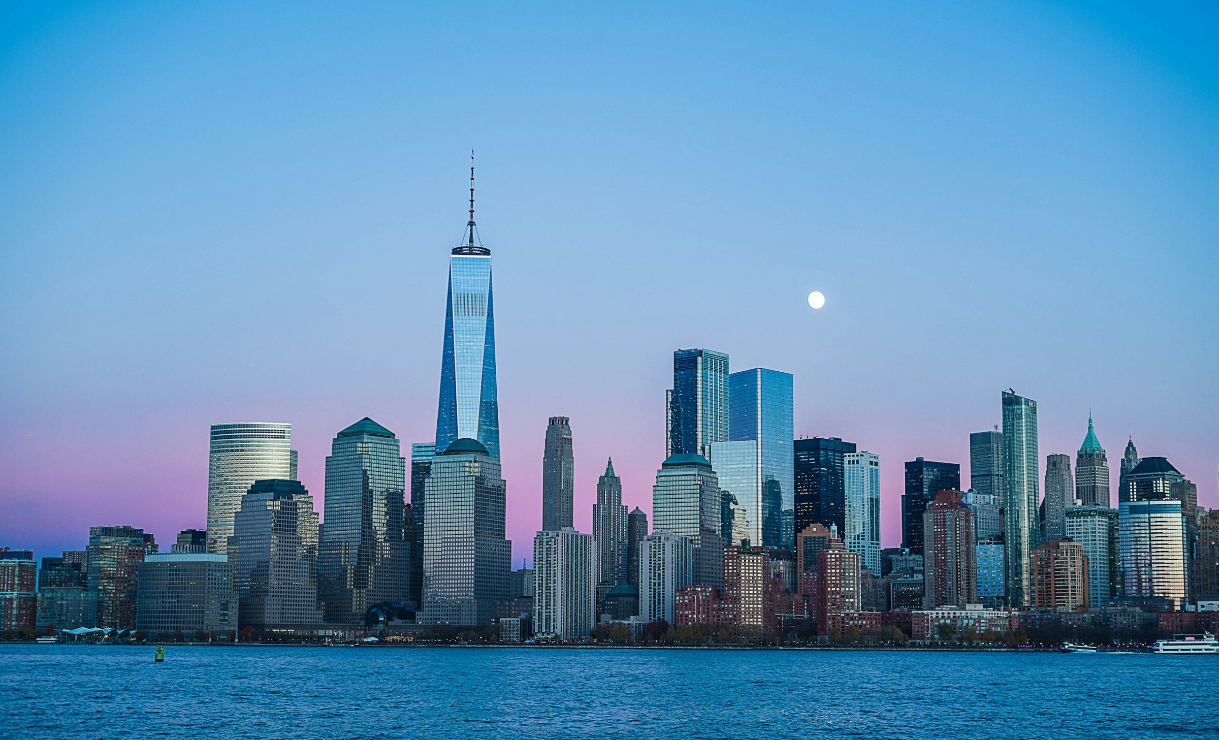 Lower Manhattan skyline at dusk across the water